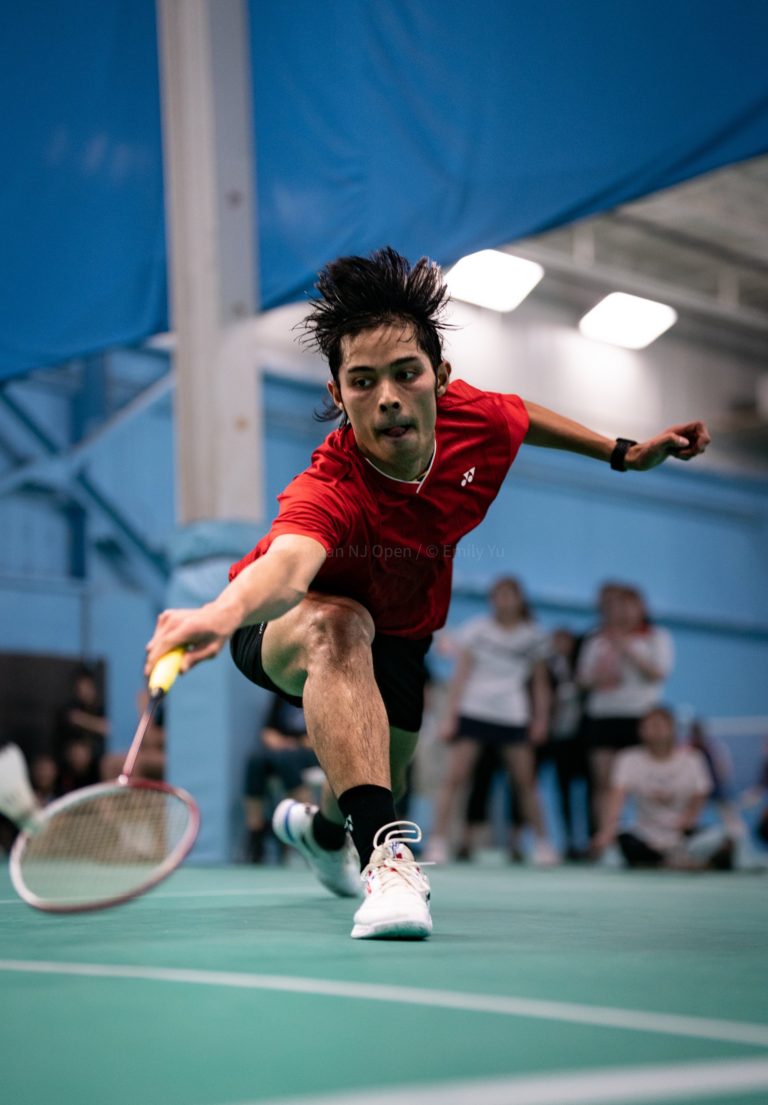 Badminton player reaching for shot